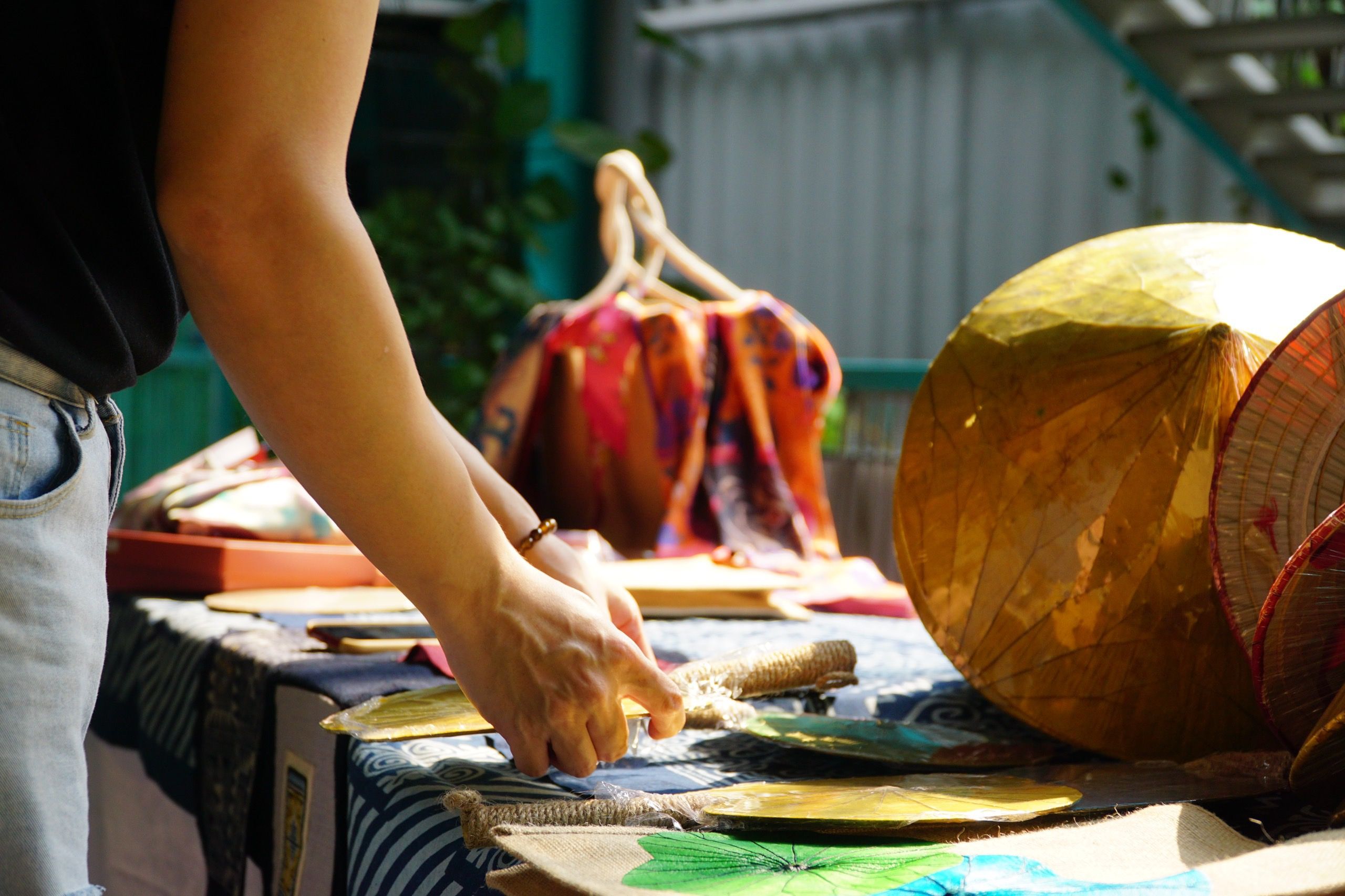 Artisan weaving traditional patterns at a riverside workshop.