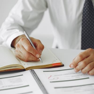 Homem escrevendo um um caderno