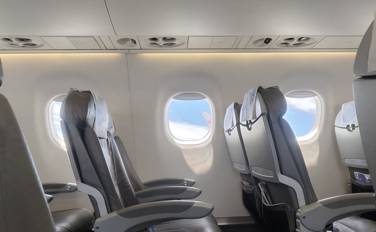 Economy class cabin showing comfortable seating arrangements and travel gear for long flights