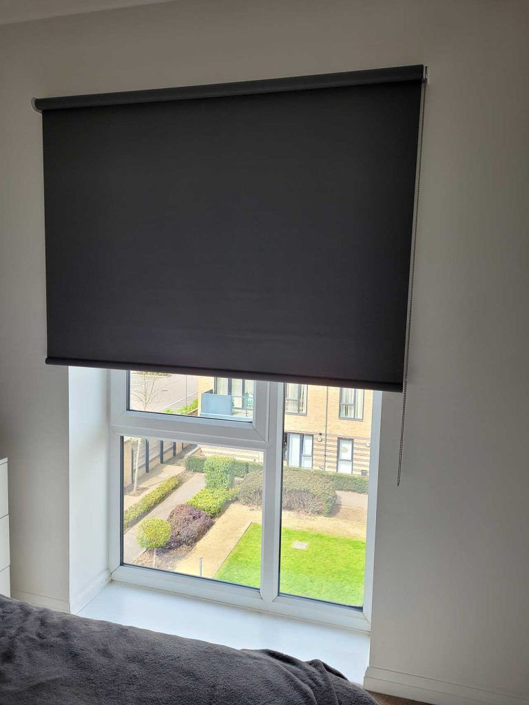 Bedroom with blackout Roman shades for complete darkness