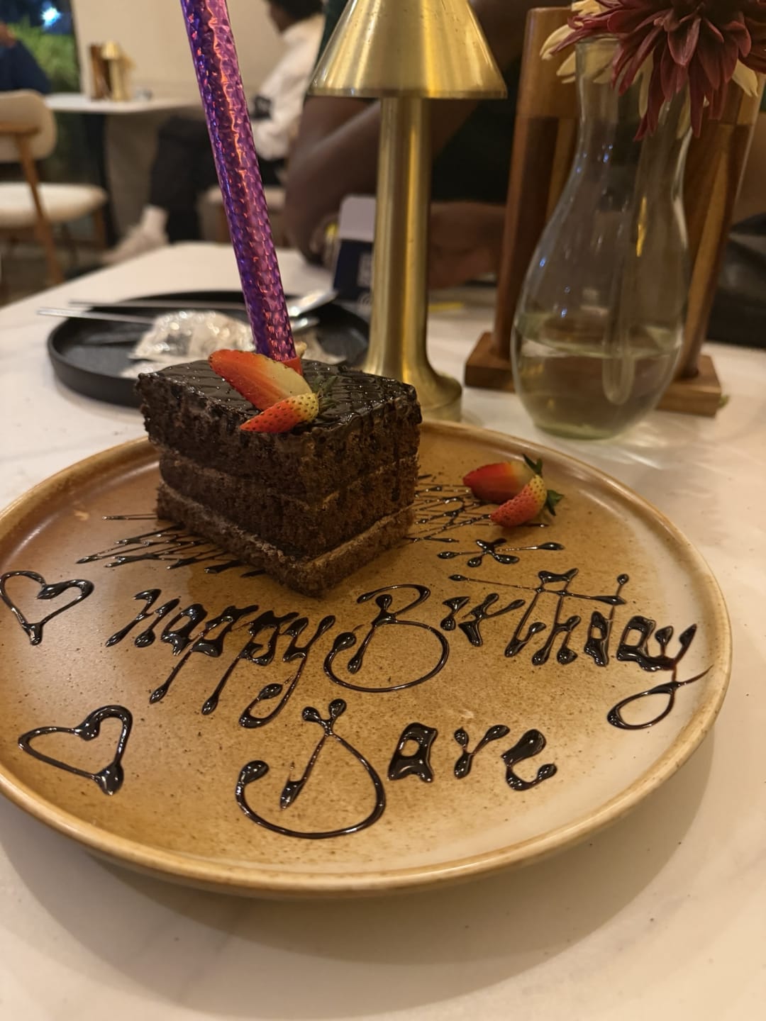 Chocolate birthday cake with strawberries and 'Happy Birthday Dave' written in chocolate on the plate at Artisan Blend Kilimani