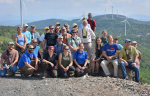 The group is shown during a field trip to a wind farm. Peg standing far left. Tom kneeling center second row. Dr. Todd Katzner stands above all others in the red shirt. Photo by Craig Koppie.