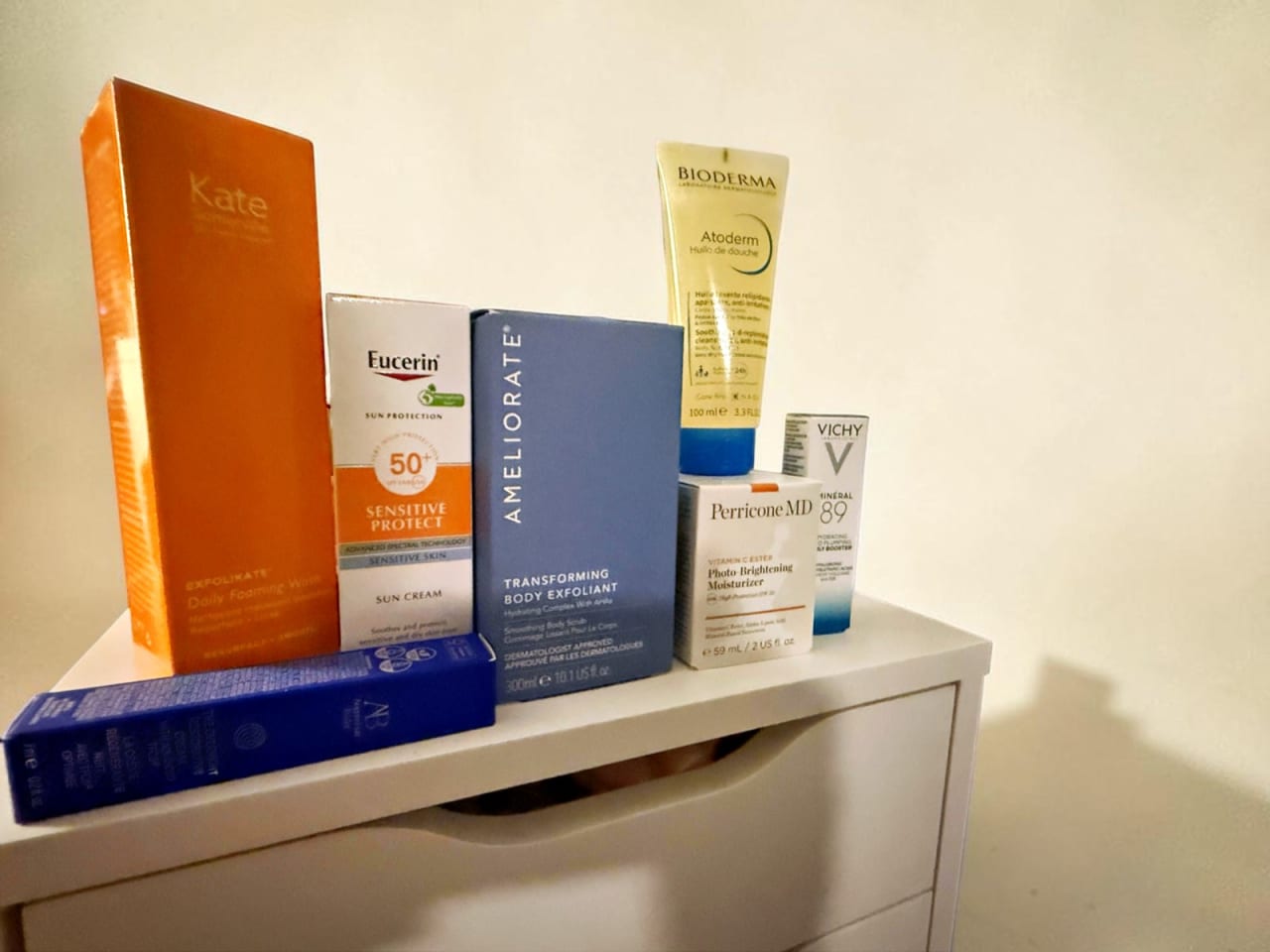 Everything in the LOOKFANTASTIC Dermatological Edit 2026 lined up: Kate Somerville ExfoliKate, Eucerin SPF 50+, AMELIORATE, Bioderma Atoderm, Perricone MD, Vichy Mineral 89 and Augustinus Bader