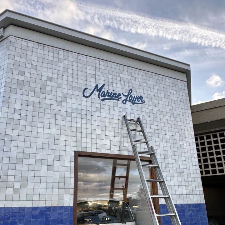 Marine Layer Exterior Script Sign Installed With Ladder, custom signage project in the San Francisco Bay Area.
