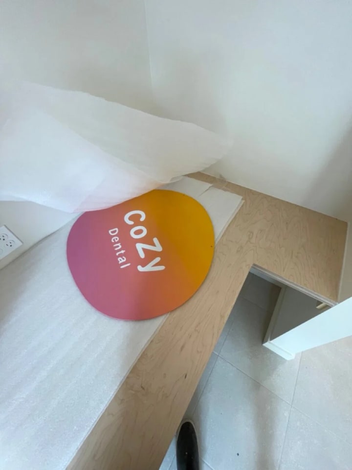 Custom cut and painted metal hanging blade sign for Cozy Dental in San Francisco's Dogpatch area, featuring a unique sunset fade artwork.