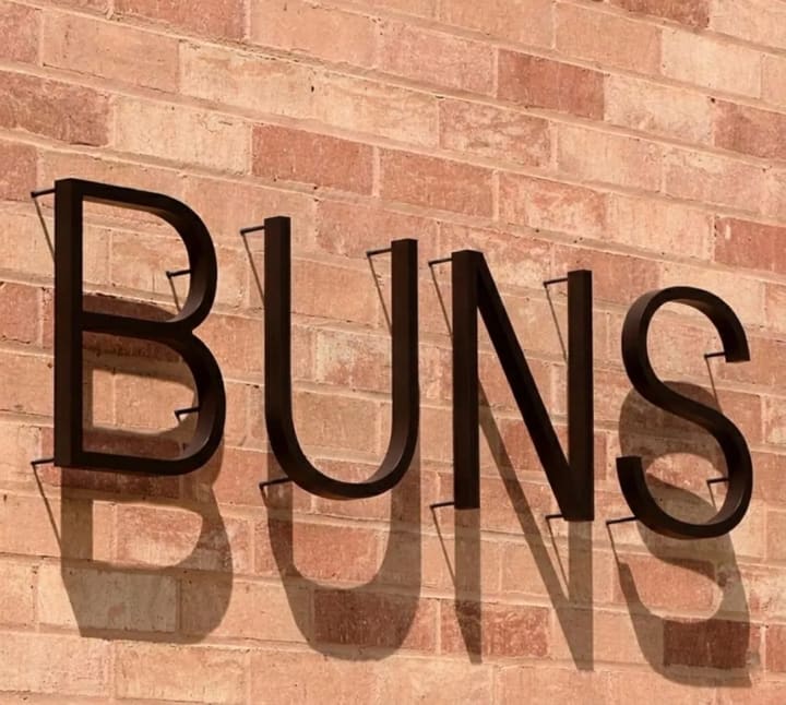Reference image of raised exterior lettering casting shadows on a facade
