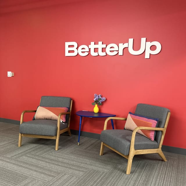 White BetterUp dimensional letters on a red lobby wall