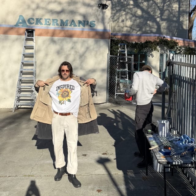 Crew members beside ladders and an Ackerman’s painted wall sign in the Sacramento region