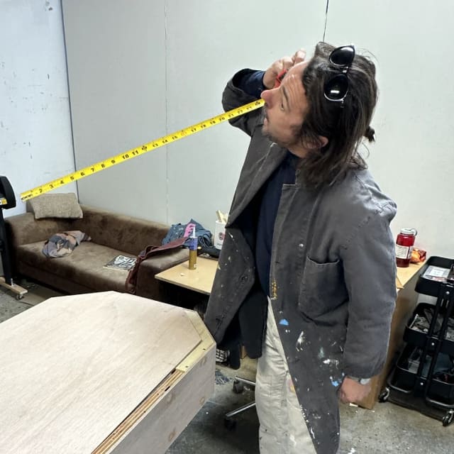 Crew member holding an extended tape measure in the workshop in Sacramento