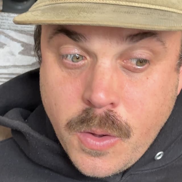 Crew member wearing a brimmed hat and dark hoodie in the Sacramento area