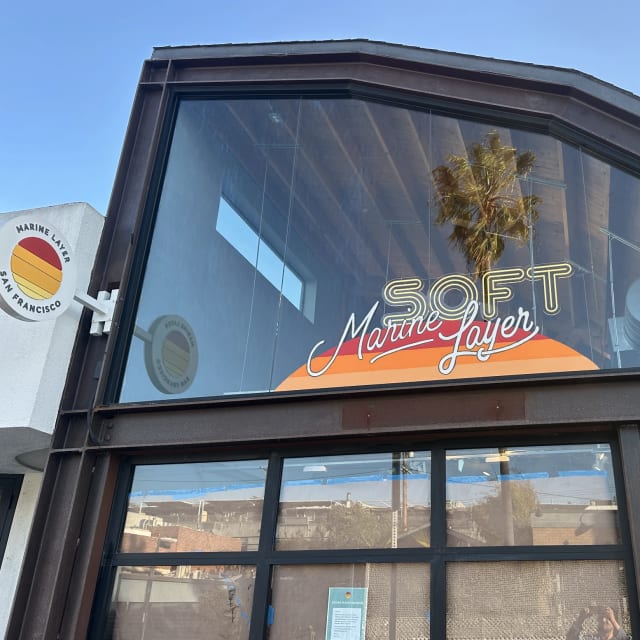 Marine Layer logo and sunset graphic in an upper storefront window for a Sacramento-region client