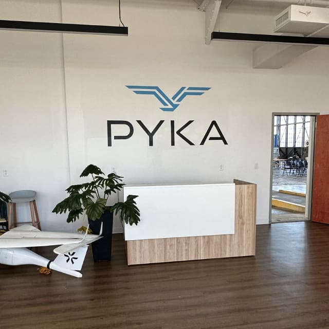 PYKA logo above a wood-fronted reception desk in the Sacramento area