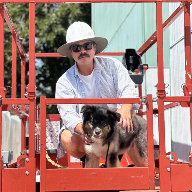 Crew member and dog sitting in a red lift basket