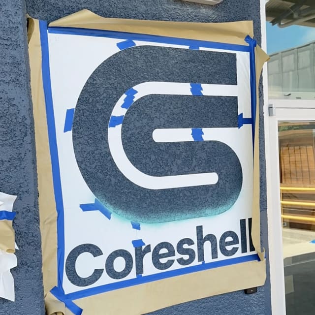 Coreshell logo stencil taped to an exterior wall