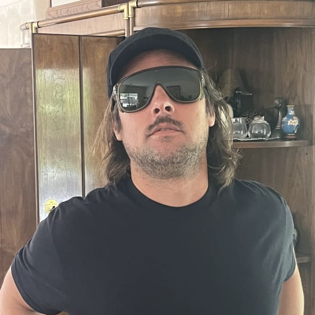 Crew member wearing sunglasses and a cap