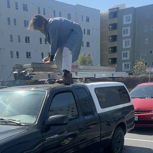Crew member securing equipment on a pickup truck’s ladder rack