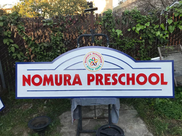 Nomura Preschool entrance sign resting on supports outdoors for a Sacramento client