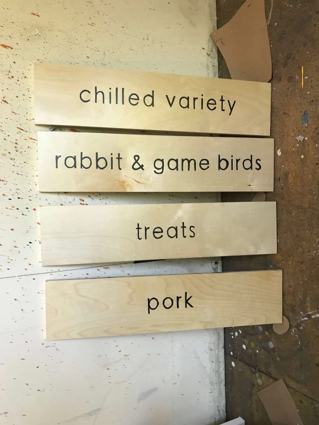 Wooden product-category signs for chilled food, rabbit and game birds, treats and pork
