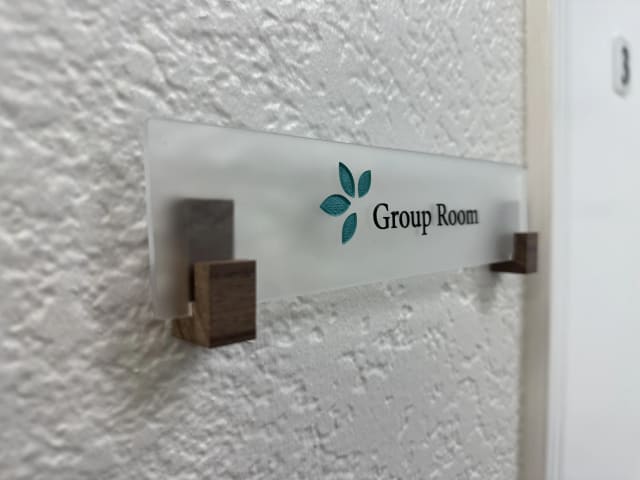 Side view of a Group Room plaque held by wooden brackets for a Sacramento office