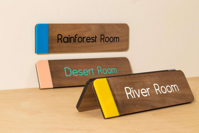 Wooden Rainforest Room, Desert Room and River Room signs with colored accents for a Sacramento office