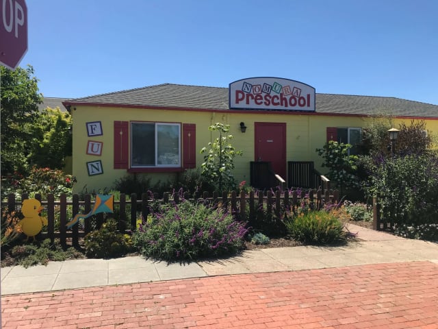 Nomura Preschool sign above a colorful entrance and garden fence