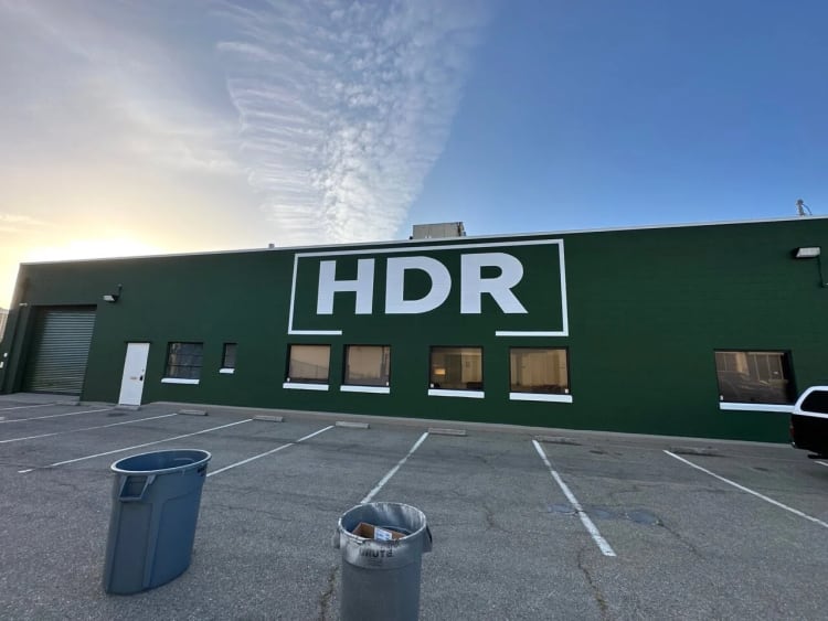 Large white HDR logo painted on a green industrial building in Emeryville.