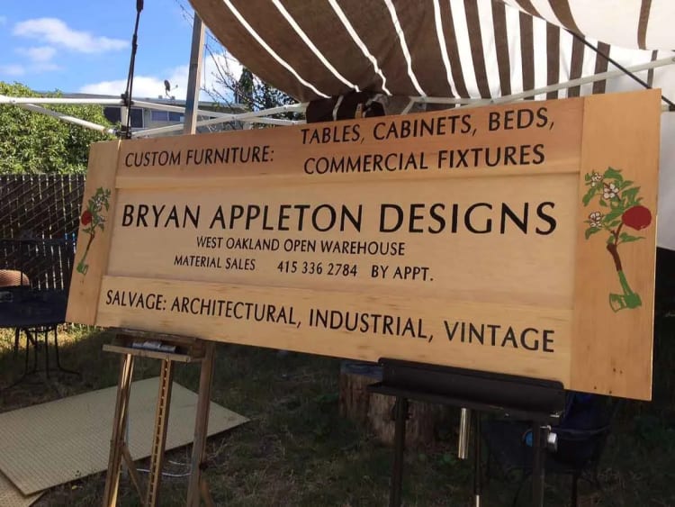Large wood Bryan Appleton Designs sign listing custom furniture and salvage services for a West Oakland open warehouse.