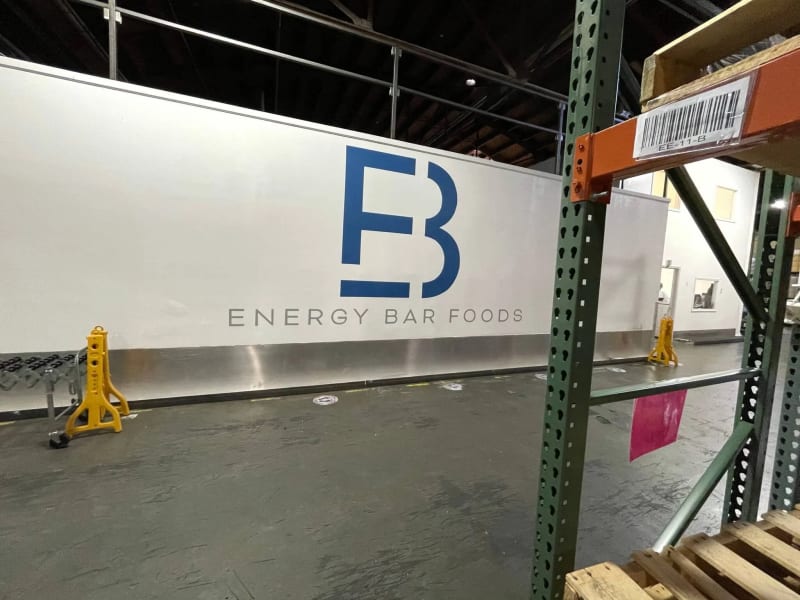 Large blue and gray company logo painted inside a Livermore food manufacturing warehouse