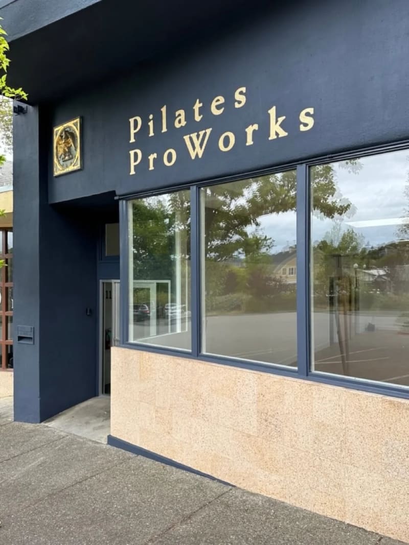 Gold Pilates ProWorks lettering on a charcoal stucco facade in Corte Madera