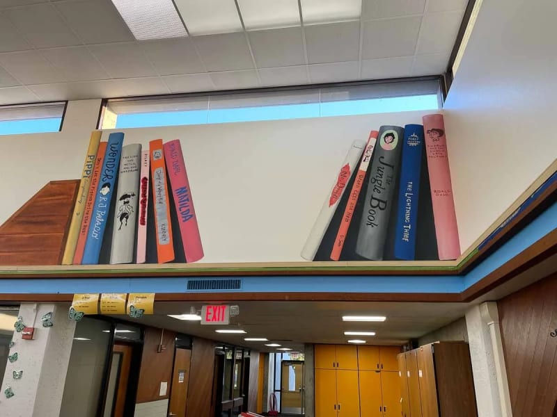 Oversized painted book spines across the Majestic Way Elementary library wall in San Jose