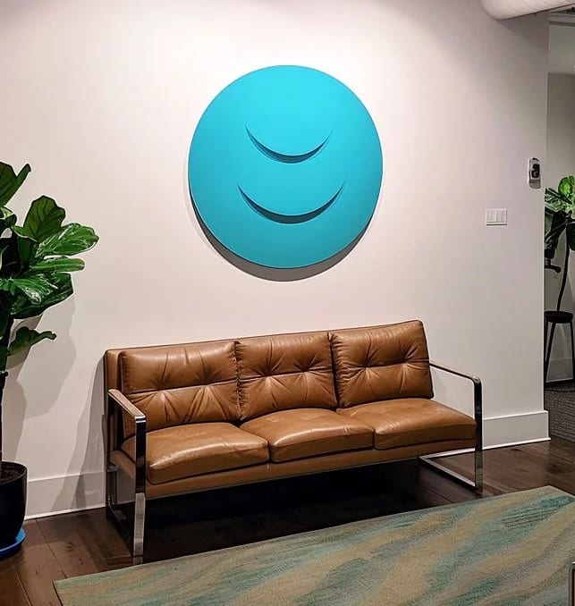 Airbrushed dimensional logo feature installed on an office lobby wall.