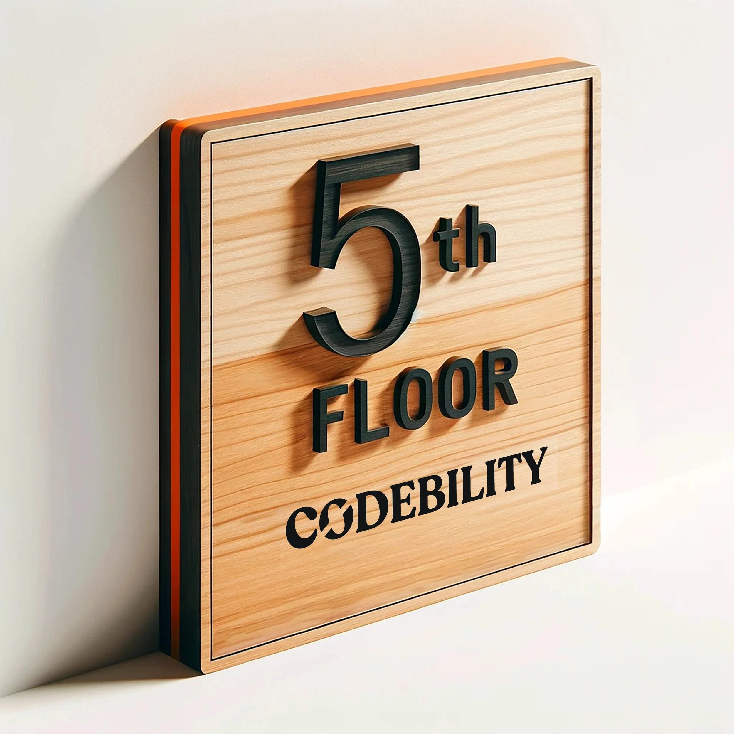 Custom oak wood wayfinding sign with orange painted edges and black vinyl lettering showing "The Fifth Floor" and "Codebility" for a Bay Area tech office.