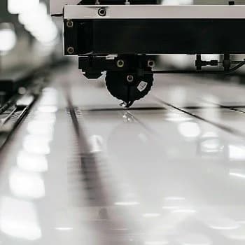 A vinyl cutter machine cutting a design from a roll of vinyl material.