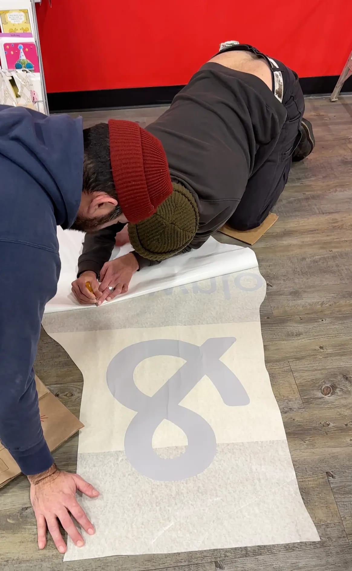 Measuring vinyl graphics on the floor during Safeway wall graphics installation