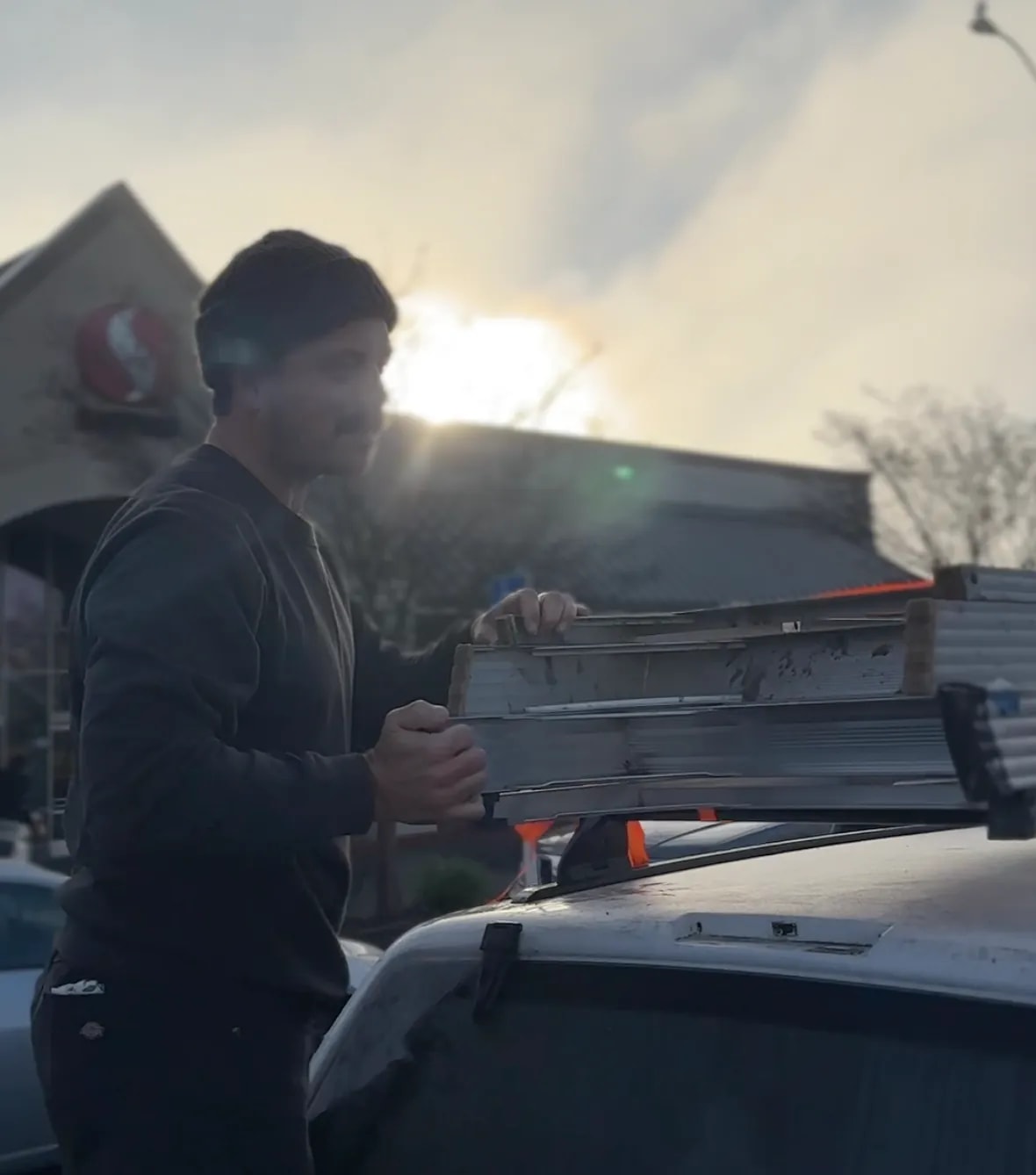Vinyl sign installation crew loading a ladder before sunrise at Safeway
