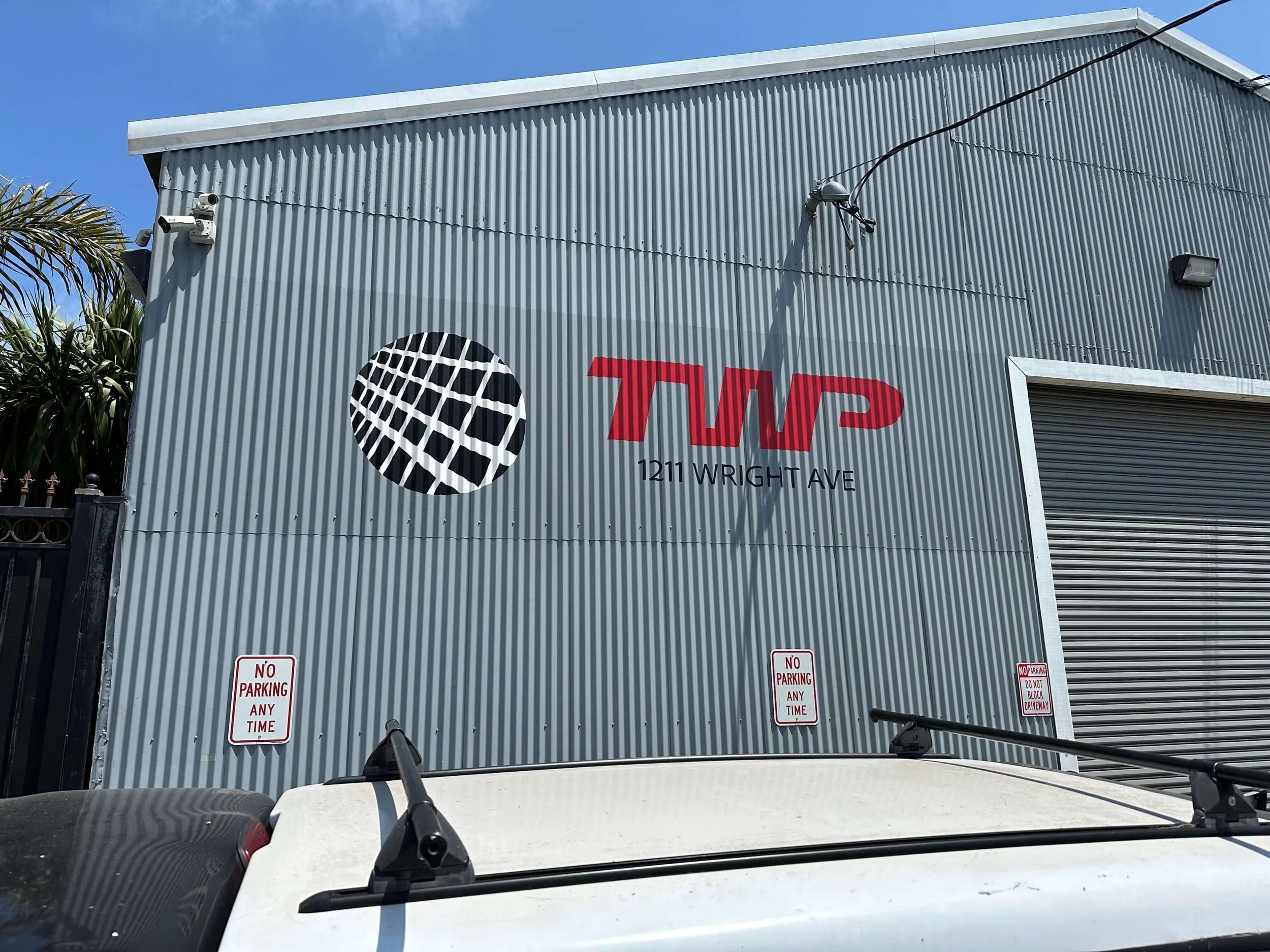 Painted exterior company signage on a corrugated metal commercial building.