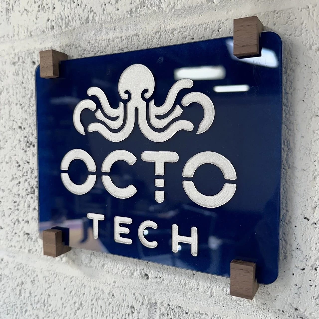 Custom office suite placard featuring blue Plexiglas with an etched logo and black walnut mounting hardware
