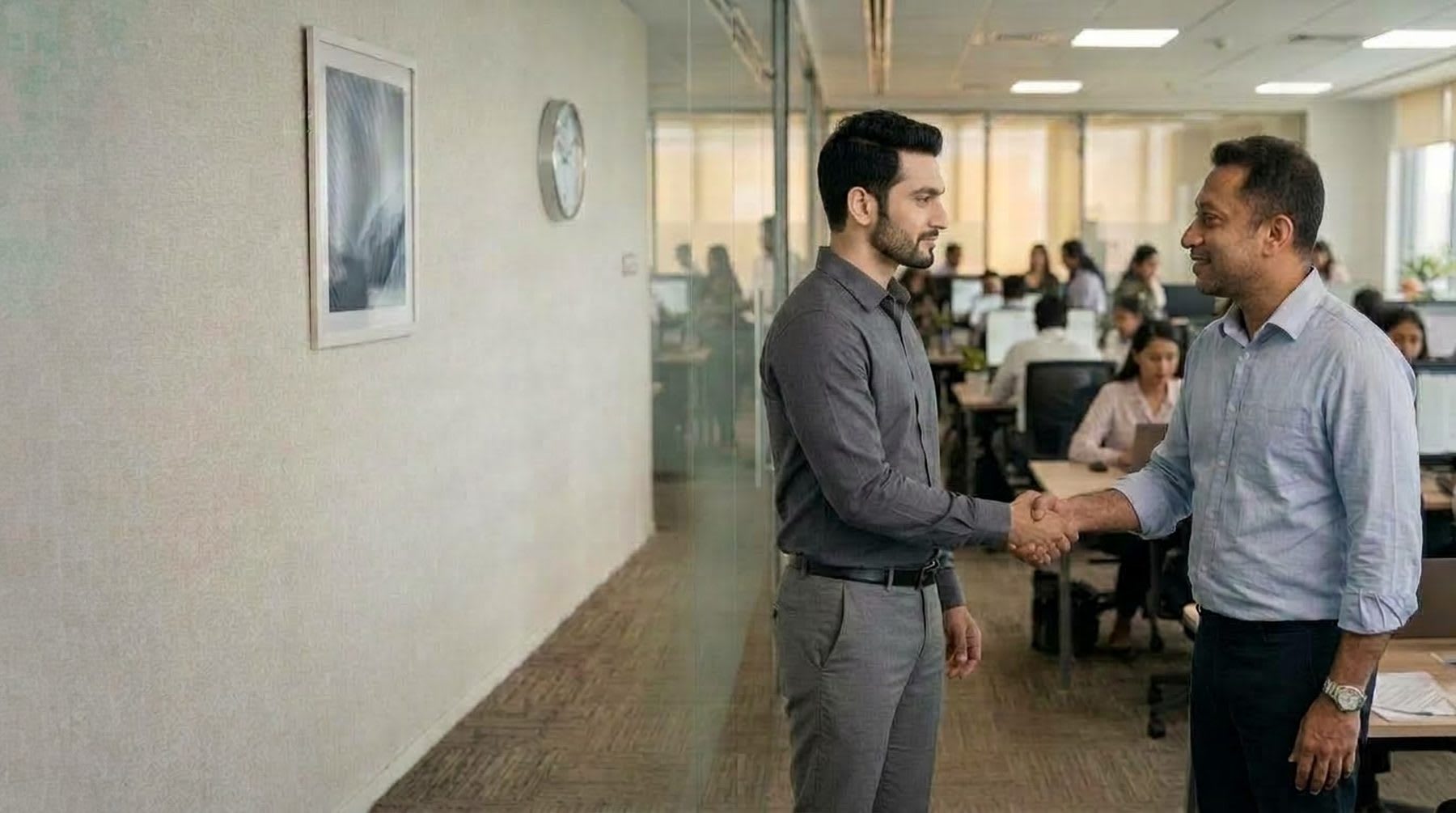 A manager shaking hands with a team member in the office