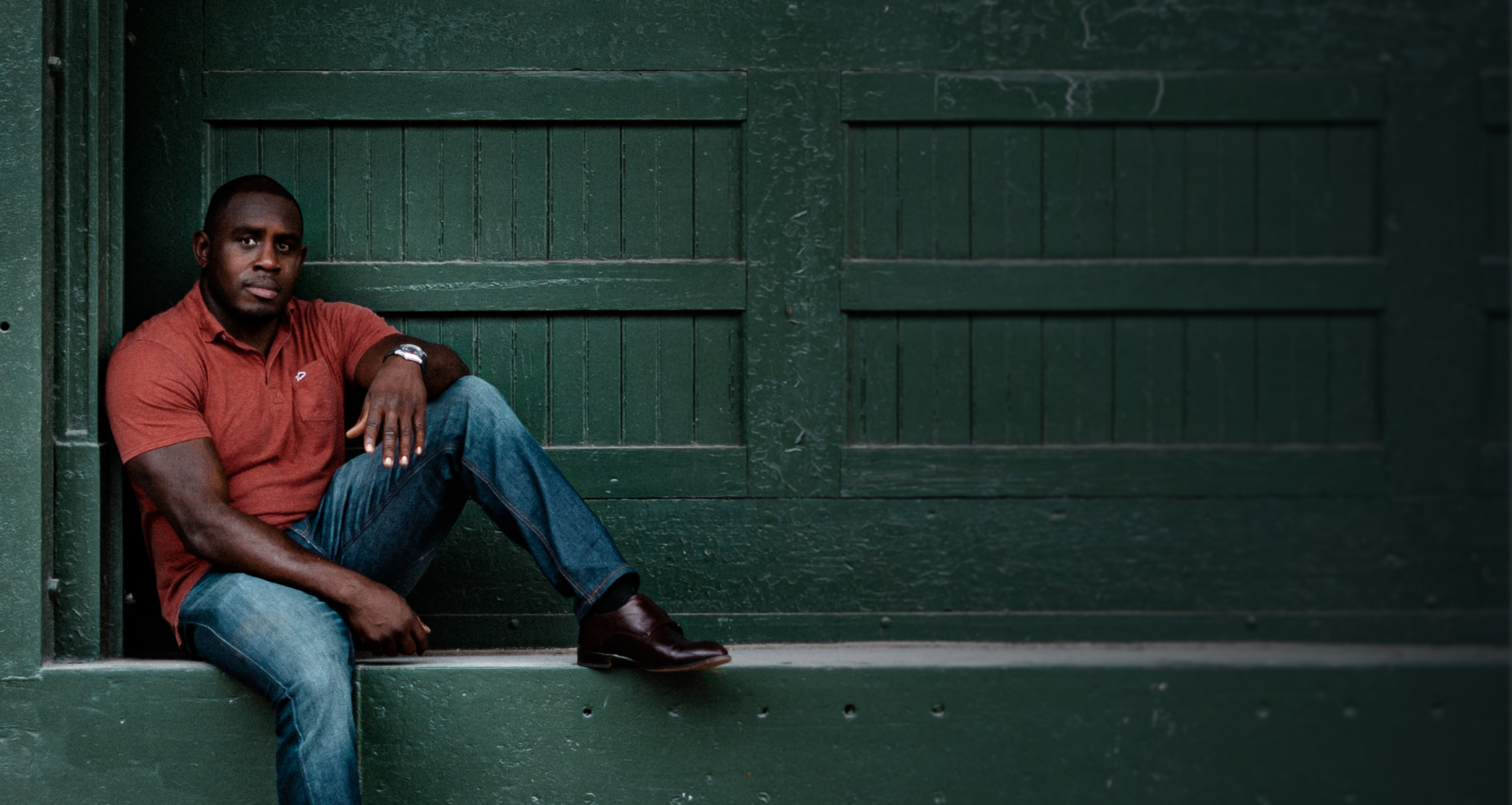Ed Latimore sitting against a green door