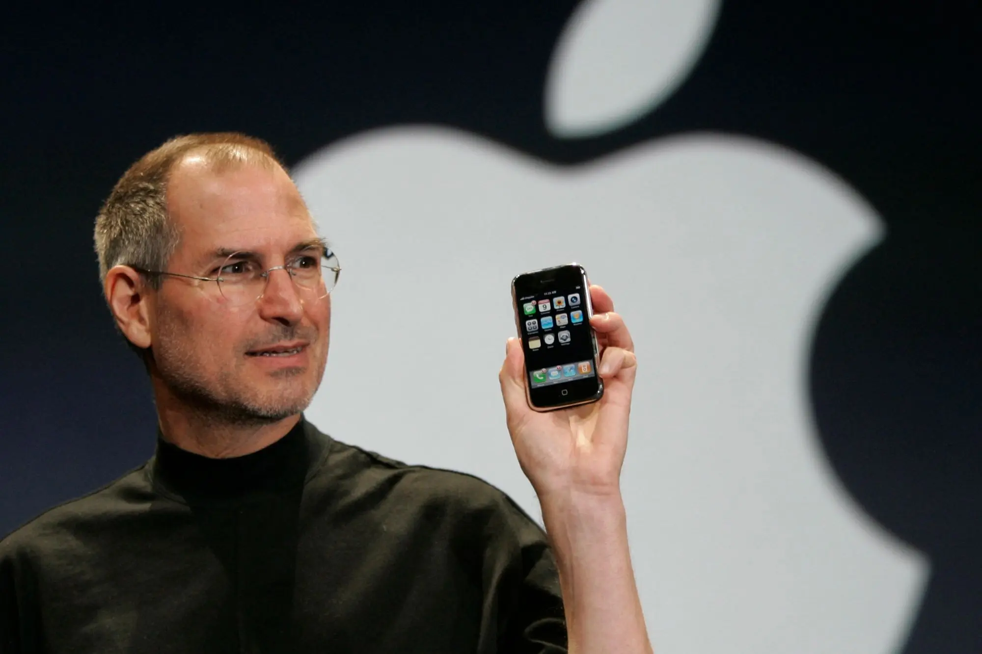 Steve Jobs holding the first iPhone on stage, illustrating Apple’s risk in disrupting its own successful product.