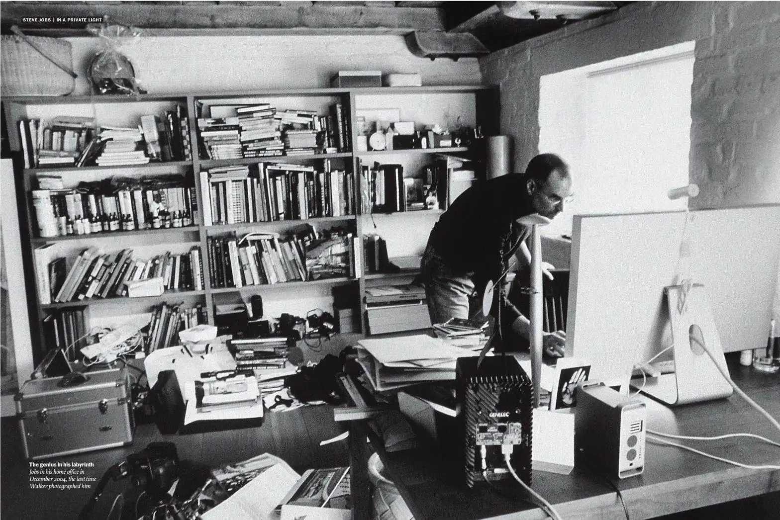 Steve Jobs at his cluttered desk, surrounded by papers and work