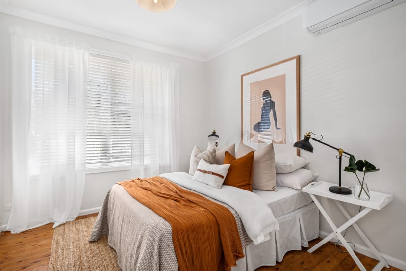 A master bedroom with lights and dominated by the white color.