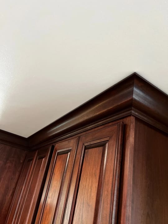 Close up photo of crown moulding and cabinet door.