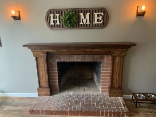 Fireplace with new wooden mantel installed.