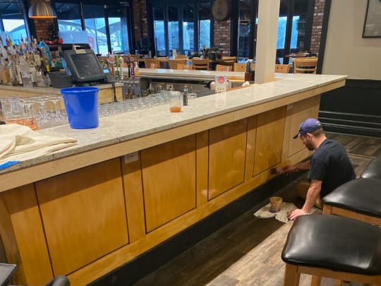 Photo of wooden panels for bar being stained.