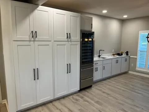 a kitchen with white cabinets and a stainless steel stove top oven and wine rack