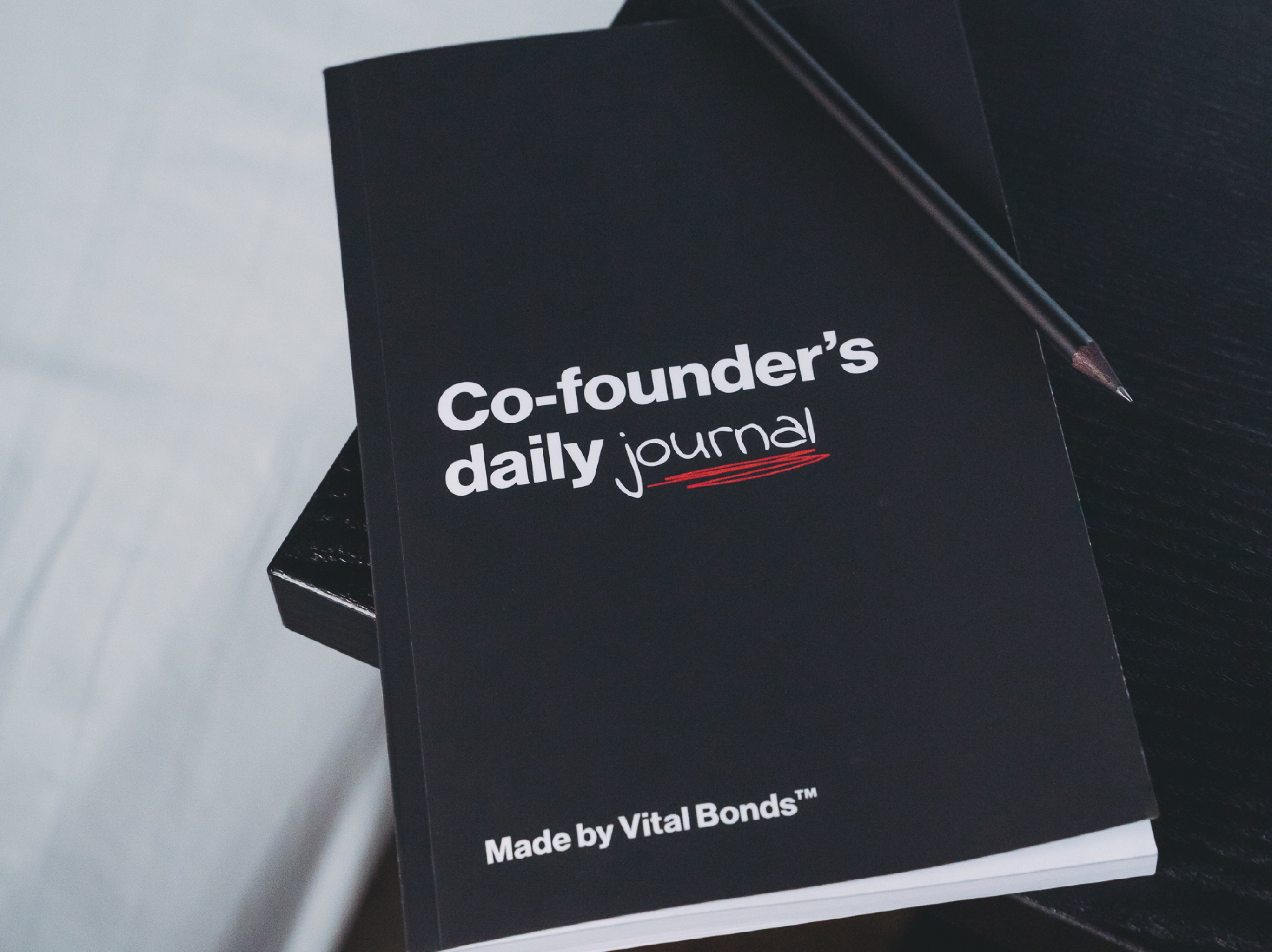 Co-founder’s Daily Journal sitting on a black table