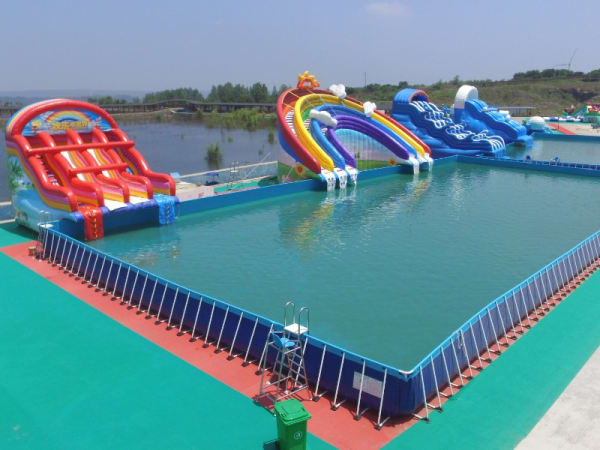 Aerial view of a massive turnkey commercial inflatable water park, featuring heavy-duty bespoke slides and a giant frame pool designed for high-capacity family entertainment center operations.