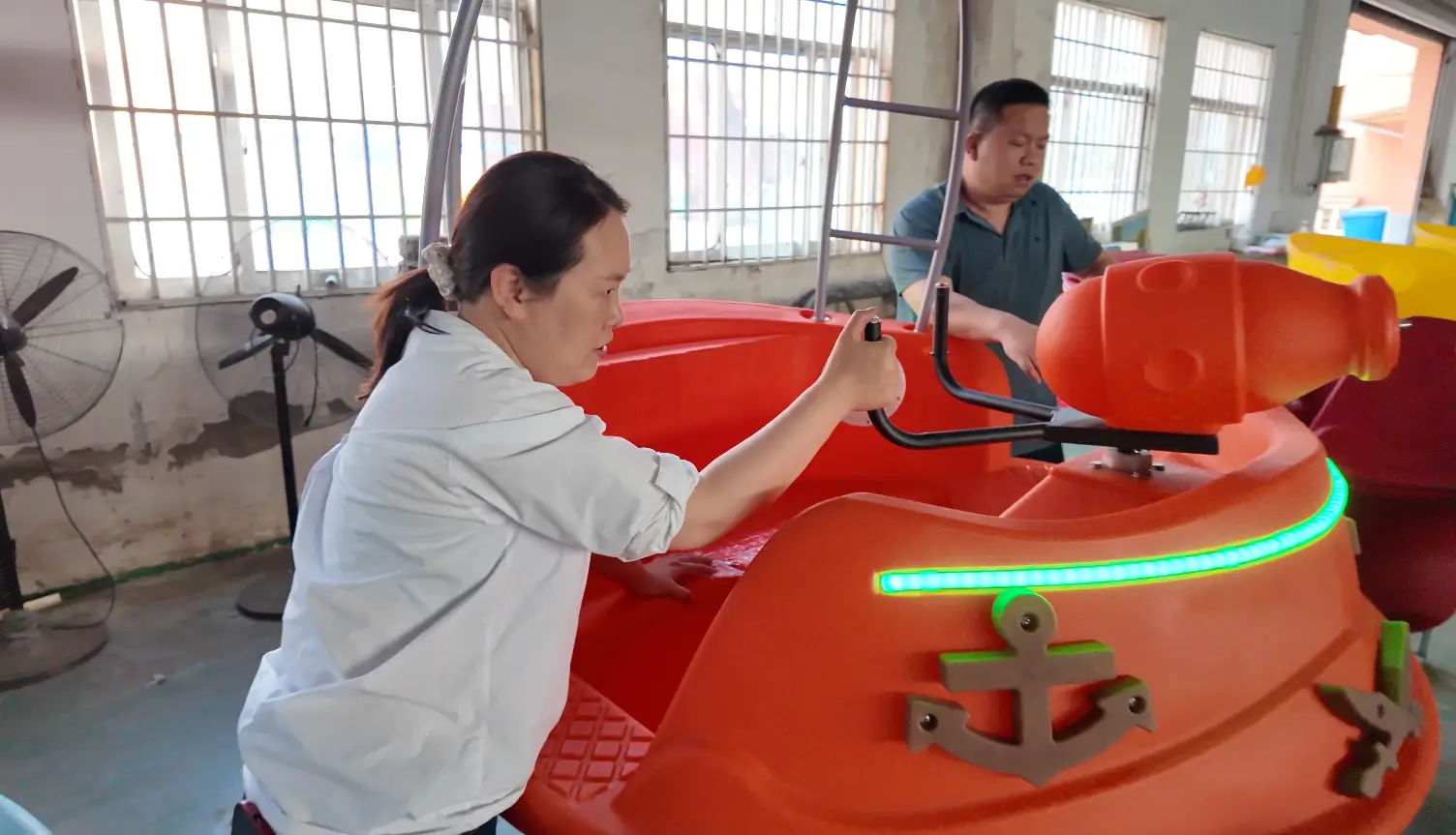 Emily, founder of Qiqu Fun, personally inspecting a heavy-duty rotomolded pirate bumper boat at our Siyang assembly and QC base.