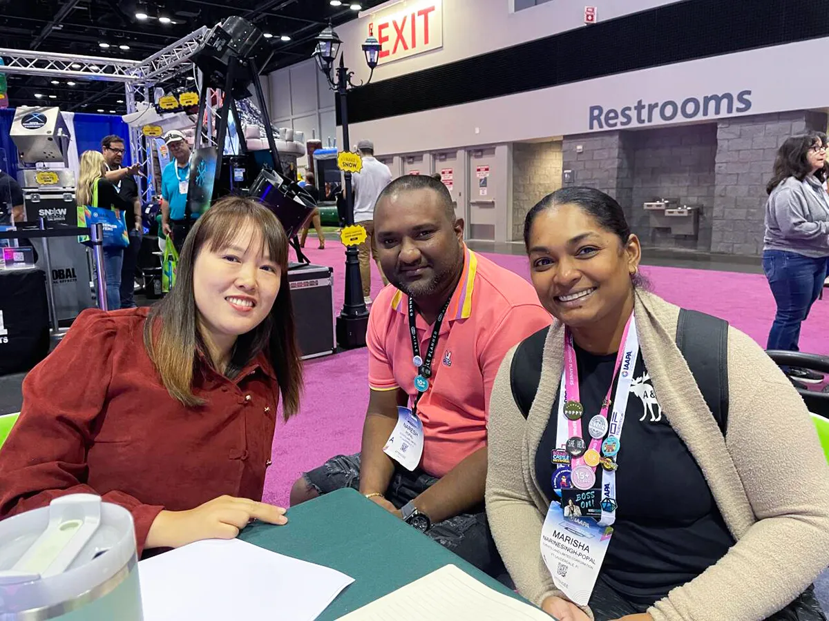Shanghai Qiqu Fun Founder Emily discussing long-term commercial amusement ride procurement strategies with loyal North American park operators at IAAPA Expo Orlando 2023